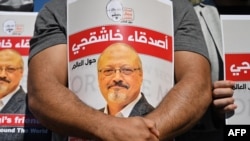 Rekan-rekan wartawan Saudi, Jamal Khashoggi, memegang poster bergambar foto dirinya dalam acara peringatan dua tahun pembunuhan Khashoggi. Acara itu digelar di depan Konsulat Arab Saudi di Istanbul, Turki, 20 Oktober 2021.