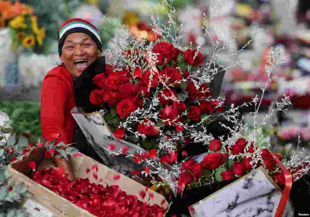 A vendor reacts as she poses for a photo at Adderley Street Flower Market on Valentine&#39;s Day in Cape Town, South Africa.