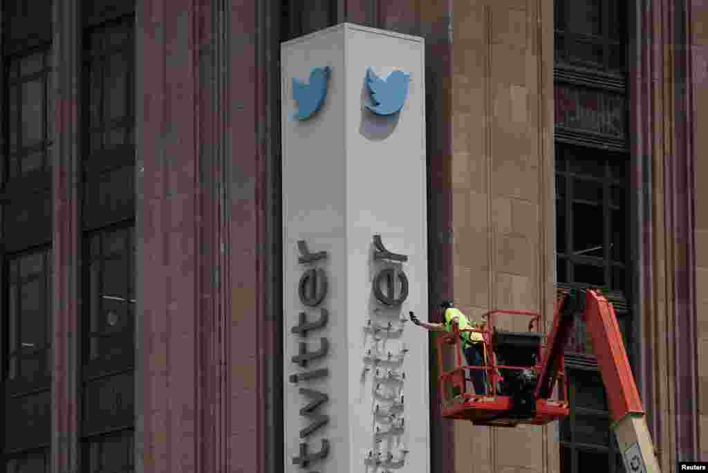 A worker dismantles a Twitter sign at Twitter&#39;s corporate headquarters, after Elon Musk renamed Twitter as X and unveiled a new logo, in downtown San Francisco, California, July 24, 2023.