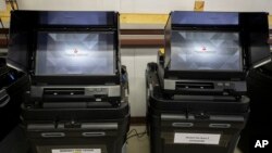 FILE - Dominion Voting ballot-counting machines are shown at a Torrance County warehouse during election equipment testing with local candidates and partisan officers in Estancia, N.M., Sept. 29, 2022.
