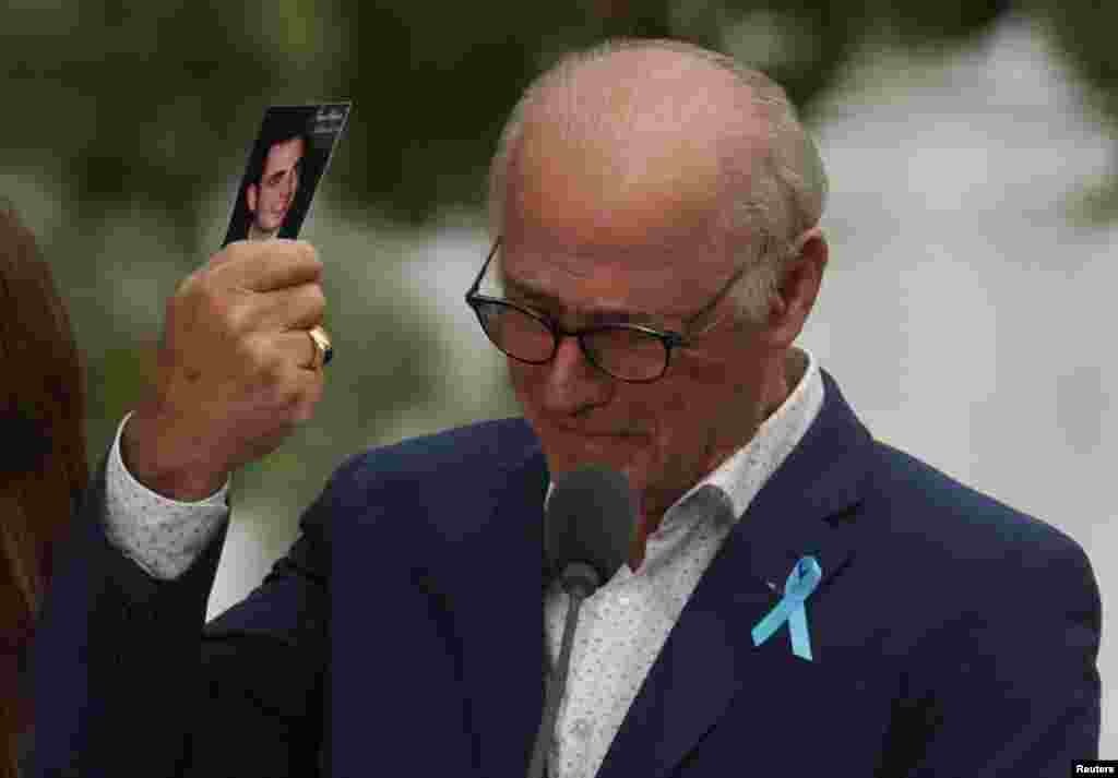 A father holds his son's picture as he attends a ceremony marking the 21st anniversary of the September 11, 2001 attacks on the World Trade Center at the 9/11 Memorial and Museum in the Manhattan borough of New York City.