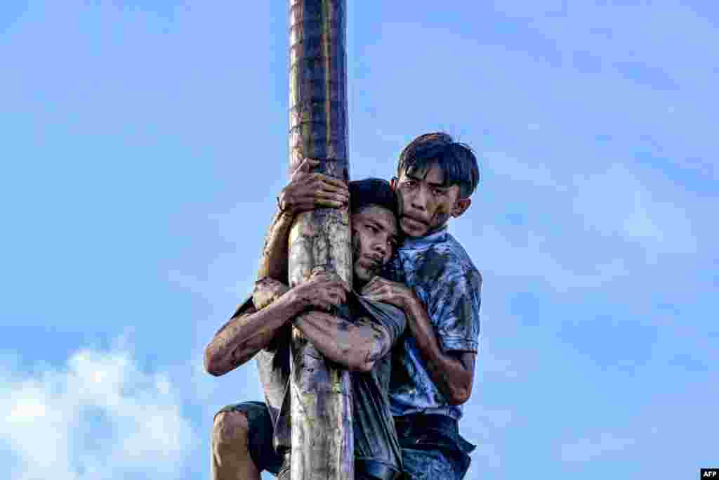 Participants climb a greasy pole called &quot;Panjat Pinang&quot; to collect prizes hung at the top during a day three of Indonesia&#39;s 78th Independence Day, in Banda Aceh, Indonesia.