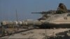 An Israeli soldier sits atop a tank in a staging area near the Gaza border in southern Israel, May 24, 2024. 