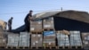 A man unloads humanitarian aid on a convoy of lorries entering the Gaza Strip from Egypt via the Rafah border crossing, Oct. 21, 2023. 