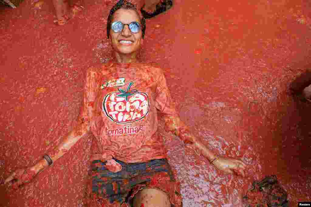 A participant lies in tomato pulp during 'La Tomatina' in Bunol, near Valencia, Spain, Aug. 28, 2024.