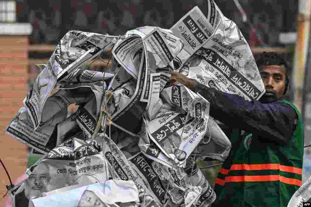 A civic worker dumps election posters in a van a day after the Awami League party led by prime minister Sheikh Hasina won Bangladesh&#39;s parliamentary elections, in Dhaka.