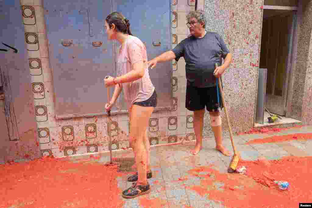 Local residents clean up tomato pulp after the annual food fight festival 'La Tomatina' in Bunol, near Valencia, Spain, Aug. 28, 2024.