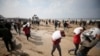 Sejumlah warga Palestina membawa kantung berisi terigu yang mereka ambil dari truk pembawa bantuan yang masuk ke Kota Gaza, pada 19 Februari 2024. (Foto: Reuters/Kosay Al Nemer)