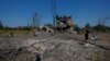 A man takes a picture of a crater that appeared during a Russian missile strike, outside of Kyiv, Ukraine, Aug. 18, 2024. 