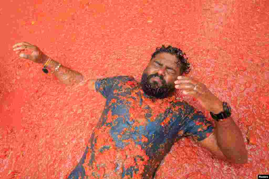 A participant lies in tomato pulp in the annual food fight festival 'La Tomatina' in Bunol, near Valencia, Spain, Aug. 28, 2024.