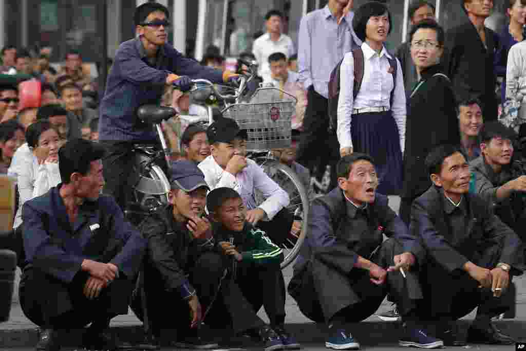 Rakyat Korut bereaksi saat mereka menonton film yang ditampilkan dalam sebuah layar raksasa di lapangan umum dekat stasiun KA Pyongyang.