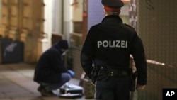 Polisi siaga sementara seorang ahli forensik memeriksa lokasi terjadinya serangan di Wina, Austria, Rabu (7/3). 