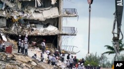 Rescue workers search in the rubble at the Champlain Towers South condominium, June 28, 2021, in the Surfside area of Miami.