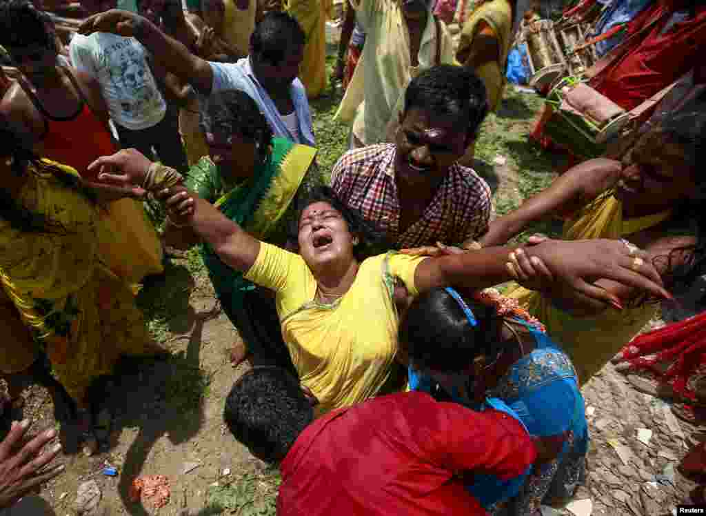 A devotee gets into a trance during a religious procession dedicated to Goddess Mariamman in Mumbai, India.