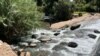 Zimbabweans use river water for chores despite raw sewage flowing in Harare. (Columbus Mavhunga/VOA)