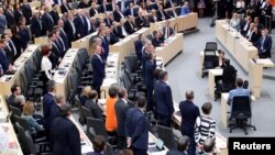 Members of the Parliament stand during a session of the Parliament in Vienna, Austria, May 27, 2019.