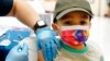 Un enfant reçoit une dose de vaccin anti-covid dans une école primaire, novembre 2021.