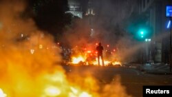 A man stands between bonfires lit by demonstrators as they clashed with police during an anti-government protest in Rio de Janeiro, Brazil, June 20, 2013. 