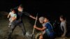 FILE - Families walk to turn themselves in to the U.S. Border Patrol after crossing the Rio Grande River into the United States from Mexico, in Roma, Texas, April 27, 2021. 