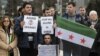 Demonstrators holding a Free Syria flag and placards reading "Stop the killing in Syria" take part in a protest outside the United Nations (UN) offices in Geneva, on Jan. 29, 2016 on the opening day of Syrian peace talks.
