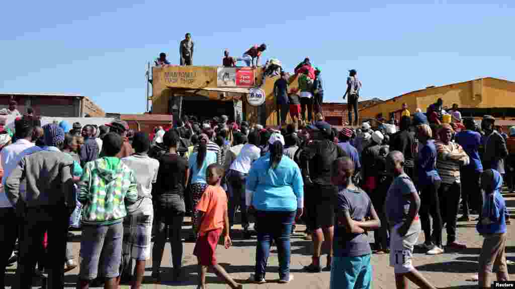 Les manifestant tentent d&#39;accéder à une boutique lors des manifestations à Atteridgeville en Afrique du Sud, le 21 juin 2016.