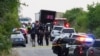 Des agents des forces de l'ordre sur les lieux où 46 personnes ont été retrouvées mortes à l'intérieur d'un camion-remorque à San Antonio, au Texas (États-Unis), le 27 juin 2022. 