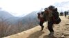 FILE - Nepalese porters carry heavy loads for climbers on their way to Everest Base Camp at Kyangjuma, Nepal in this April 7, 2015 photo.. 