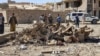 Security personnel and residents gather around the site of a car bomb attack that targeted an Afghan police headquarters in Feroz Koh, the capital of Ghor Province, Oct. 18, 2020. (AFP)