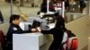 FILE - A foreign airline passenger hands travel documents to a Customs and Border Protection Officer at Hartsfield-Jackson International Airport in Atlanta, Georgia, Jan. 5, 2004. 