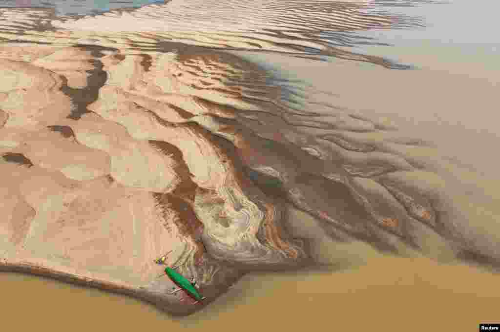 A drone view shows Reis Santo Vieira da Silva as a river dweller builds a canoe on the sandbanks of Madeira River during the worst drought of the river in history, in Humaita, Amazonas state, Brazil, Sept. 7, 2024.