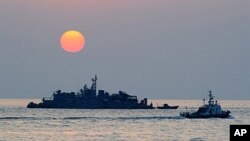 FILE - A South Korean goverment ship (R) sails by Navy MSB (Movement Sea Base) off the South Korea-controlled island of Yeonpyeong near the disputed waters of the Yellow Sea.