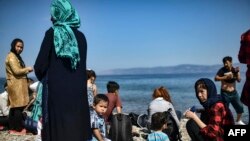 Des migrants afghans arrivent après avoir traversé la mer Égée depuis la Turquie avec un canot pneumatique sur l'île grecque de Lesbos, le 6 août 2018.