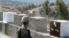 FILE - A Pakistani soldier stands guard at a border fence between Pakistan and Afghanistan, at Angore Adda, Pakistan, Oct. 18, 2017. Pakistan said Thursday that suspected militants operating out of Afghanistan have attacked several border outposts.