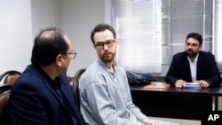 FILE - In this photo released by Mizan News Agency on Dec. 10, 2023, Swedish citizen Johan Floderus, center, sits at a courtroom at the Revolutionary Court in Tehran, Iran.
