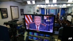 Predsjednik Donald Trump vidi se na ekranima u sobi za brifinge Bijele kuće, dok se u udarnom terminu obraća naciji iz Ovalnog kabineta, 8. januara 2019.