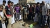 Yemenis gather at the site of a bomb explosion that targeted an army troop vehicle on its way to man a checkpoint on a street leading to two western embassies, May 9, 2014, in Sana'a. 