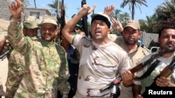 FILE - Volunteers, who have joined the Iraqi Army to fight against Sunni militant group Islamic State of Iraq and the Levant (ISIL), carry weapons during a parade in the city of Baquba, June 23, 2014.