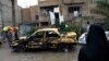 Local residents gather at the site of a car bomb explosion in the Hurriyah neighborhood of the Iraqi capital Baghdad on February 3, 2014.