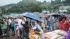 Une femme se tient avec un parapluie à côté de sacs de riz lors d'une distribution de nourriture pour les personnes déplacées à l'intérieur (PDI) de la région d'Amhara, dans la ville de Dessie, en Éthiopie, 