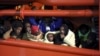 Migrants wait to disembark from a tug boat in the Sicilian harbor of Pozzallo, southern Italy, May 4, 2015.