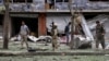 Security personnel investigate the site of a suicide attack that struck the convoy of presidential candidate Abdullah Abdullah in Kabul, June 6, 2014. 