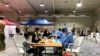 In this photo provided by the Australian Defence Force evacuees from Afghanistan are processed after arriving at Australia's main base in the Middle East region, Aug. 18, 2021, according to Australian defense. 