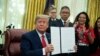 President Donald Trump shows an executive order establishing the Task Force on Missing and Murdered American Indians and Alaska Natives, in the Oval Office of the White House, Tuesday, Nov. 26, 2019, in Washington. (AP Photo/ Evan Vucci)