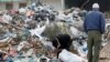 FILE - A man searches for usable items from a pile of garbage in Tunis, Tunisia, Nov. 23, 2019.