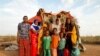 A family stands beside their shelter at a camp for internally displaced people from drought hit areas in Dollow, Somalia, April 3, 2017. 