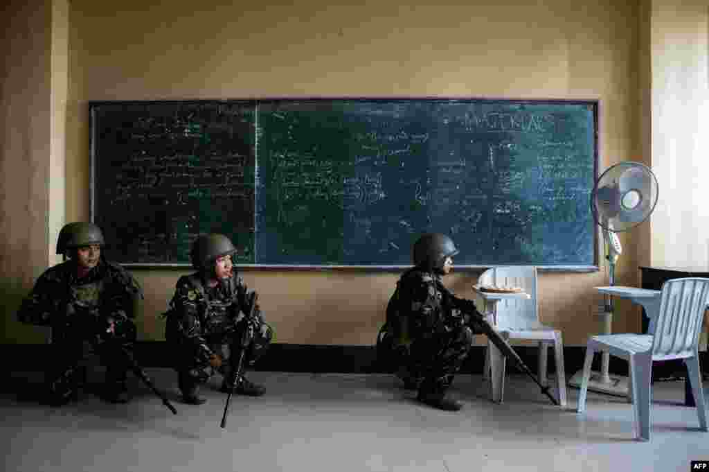 Tentara Scout Rangers Filipina merangkak di sebuah ruang kelas selama misi untuk menumpas penembak runduk militan Islamis di Marawi, sebuah pulau di selatan Mindanao.