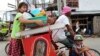 Residents with their belongings ride on a tricycle cab to an evacuation center in Tacloban city, central Philippines, Dec. 4, 2014. 