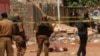 Des éléments forces de sécurité burkinabè se tiennent près du corps d'un suspect jihadiste abattu à Ouagadougou, le 22 mai 2018.(Archives)
