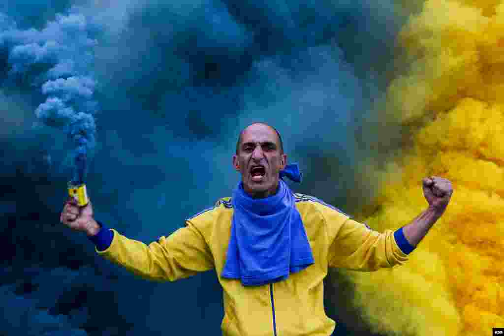 An Estoril Praia soccer team fan cheers for his team in the beginning of a Portuguese First League Soccer match at António Coimbra da Mota Stadium, Estoril, Portugal.