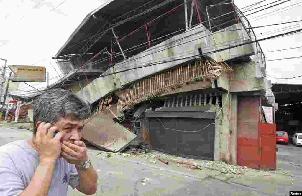 A resident walks past a building that collapsed after a magnitute of 7.2 earthquake struck in Cebu City, central Philippines.